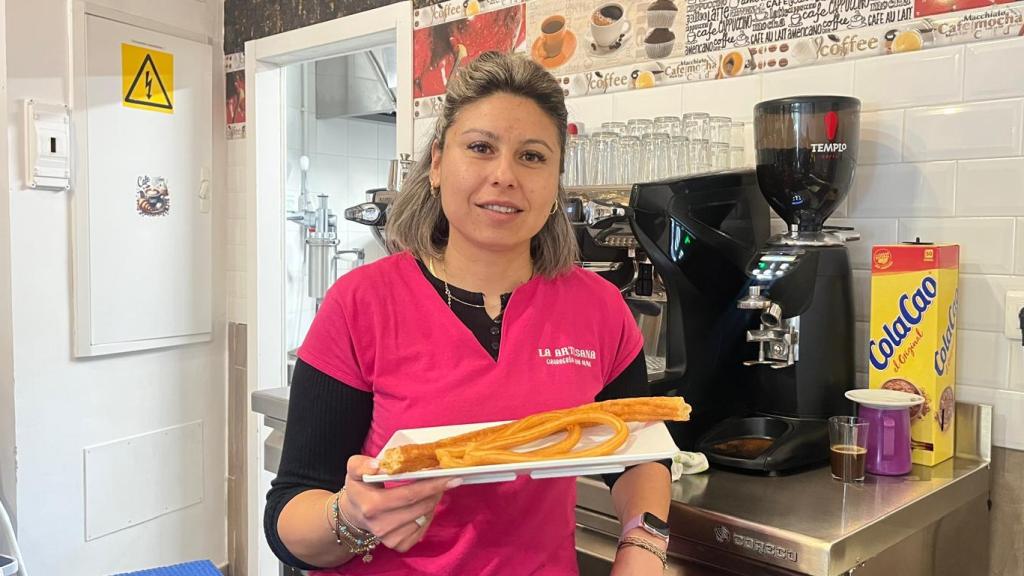 Delia en la barra de su cafetería con unos churros.