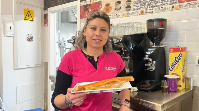 Delia en la barra de su cafetería con unos churros.