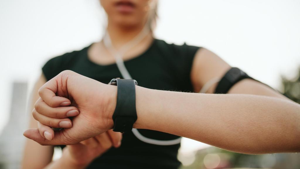 Mujer entrenando y consultando su smartwatch.