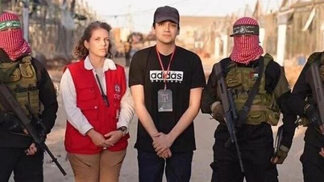 El rehén liberado Edan Alexander con una representante de la Cruz Roja y flanqueado por hombres armados de Hamás este lunes en Gaza.