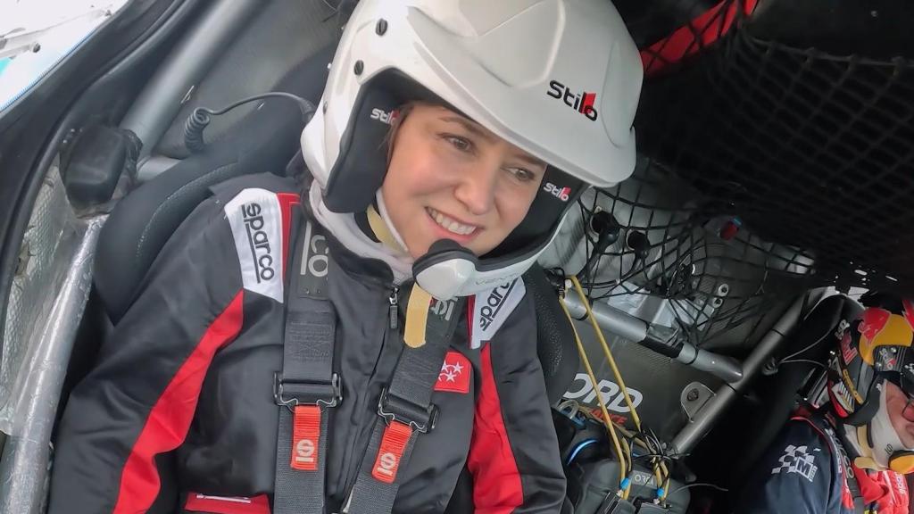 Ayuso en el coche de Carlos Sainz para dar la primera vuelta al circuito de Fórmula 1 de Madrid.