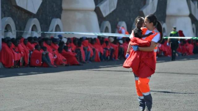 Una voluntaria de Cruz Roja atiende a una niña llegada a La Restinga, en El Hierro, el 21 de octubre.