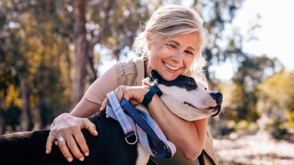 Una mujer abraza cariñosamente a su mascota.