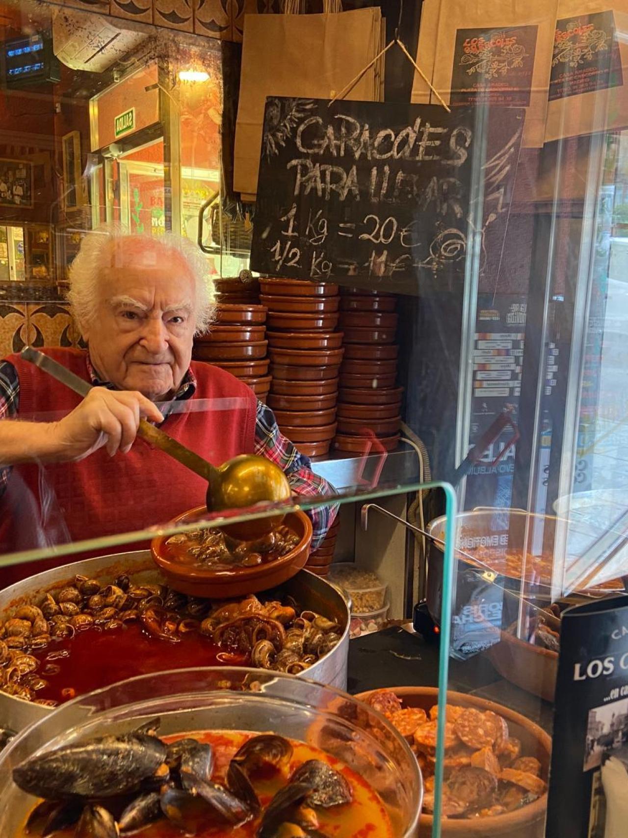 Amadeo sirviendo caracoles.