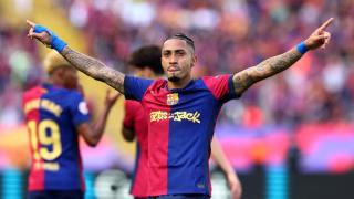 El jugador del FC Barcelona, Raphinha, celebra sobre el césped tras la victoria en el Clásico.