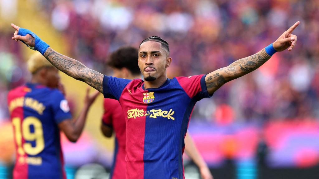 El jugador del FC Barcelona, Raphinha, celebra sobre el césped tras la victoria en el Clásico.