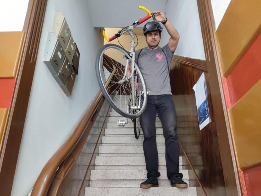 Juan Francisco Caicedo baja con su bicicleta desde su piso en la cuarta planta para ir a trabajar.