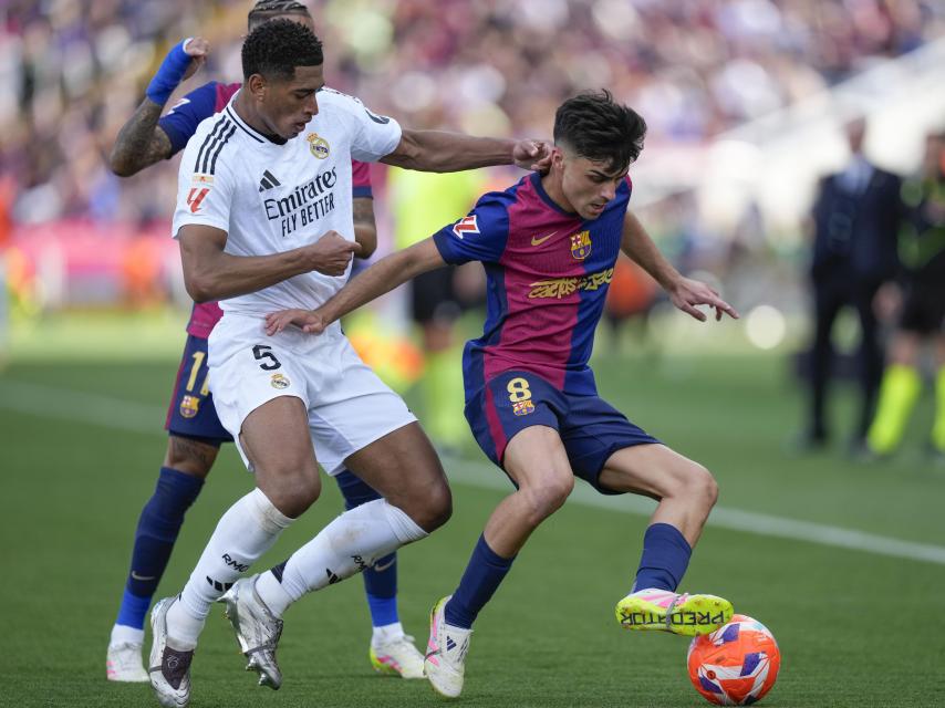 Pedri esconde el balón ante Jude Bellingham.