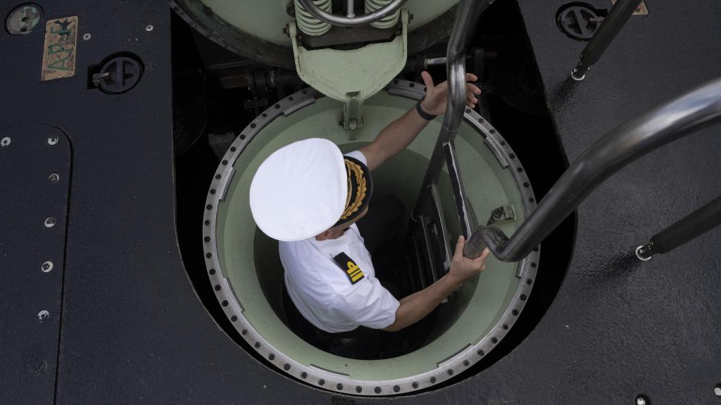 El comandante Manuel Corral baja las escalerillas de proa que dan acceso al interior del submarino S-81.
