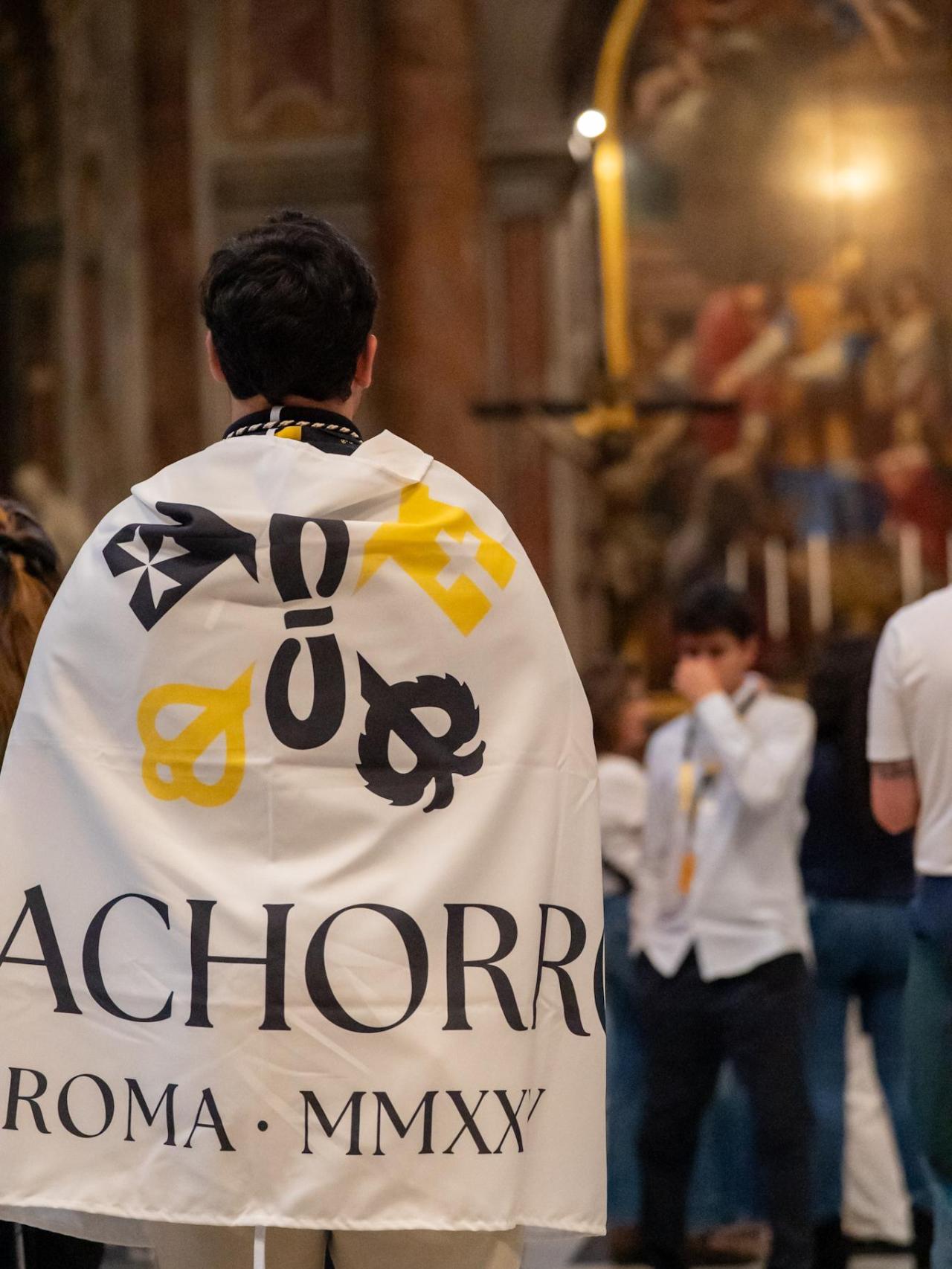 Un sevillano en la Basílica de San Pedro ataviado con la bandera de la procesión.