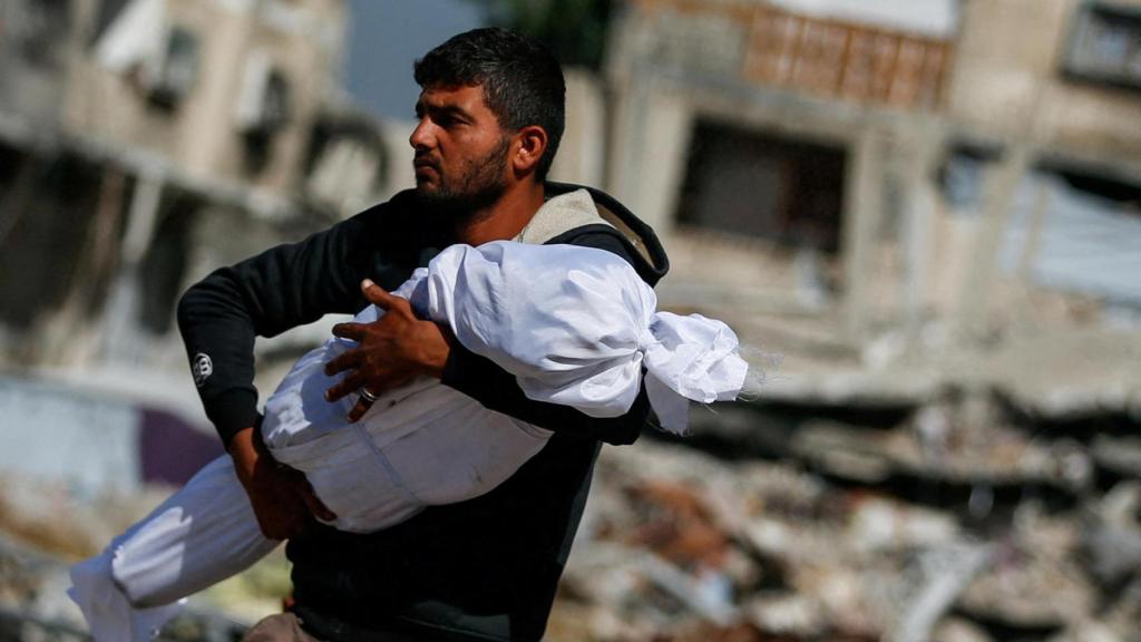 Un palestino transporta en brazos el cuerpo sin vida de un niño, tras los ataques israelíes en Jabalia, en el norte de Gaza.