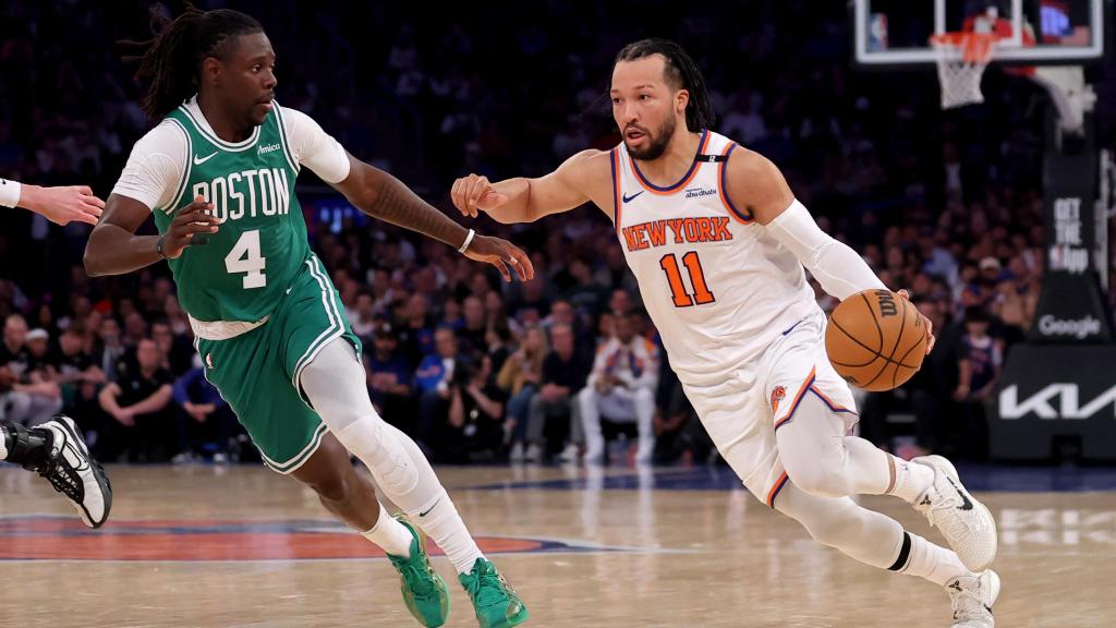 Jalen Brunson penetra a canasta defendido por Jrue Holiday.
