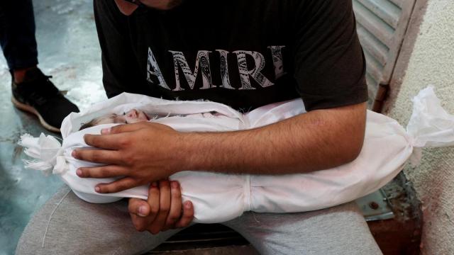 Una padre sostiene a su hijo muerto por los ataques de Israel este domingo en Deir Al-Balah, en el centro de la Franja de Gaza.