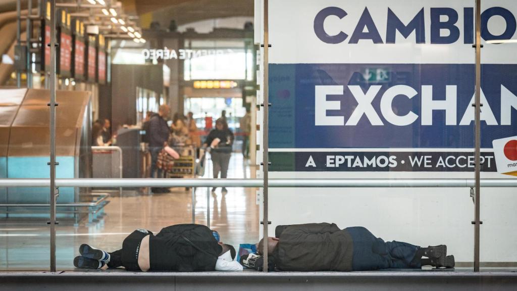 Dos personas duermen en la T4 del Aeropuerto Adolfo Suárez-Madrid Barajas, a 12 de mayo de 2025, en Madri
