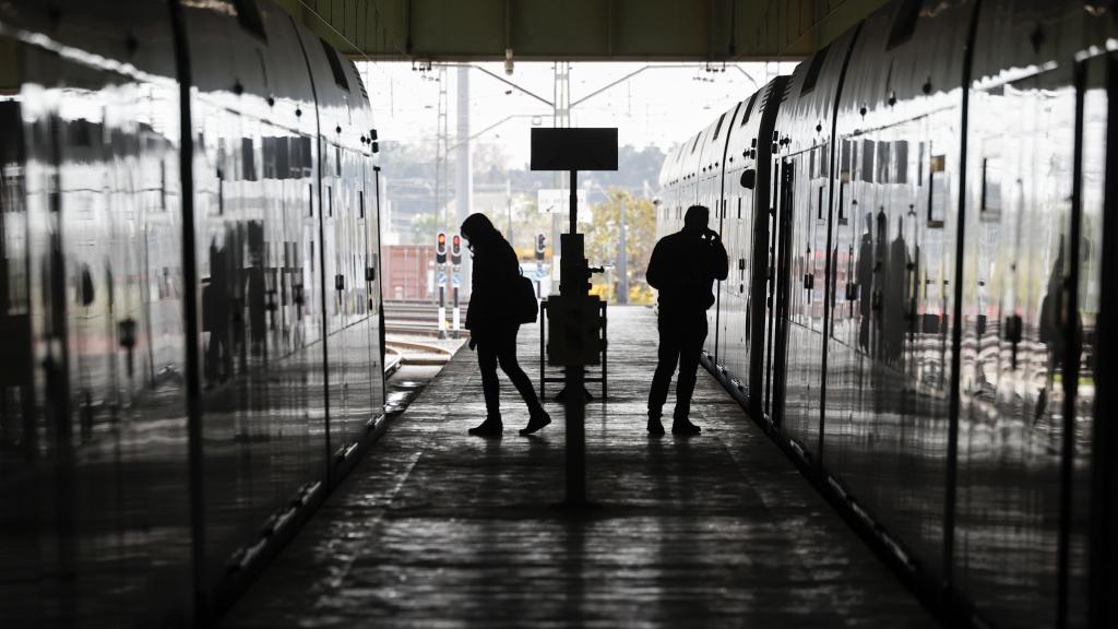 Dos personas transitan entre dos vagones de metro en los talleres de Metrovalencia, en una imagen de archivo. Efe / Biel Aliño
