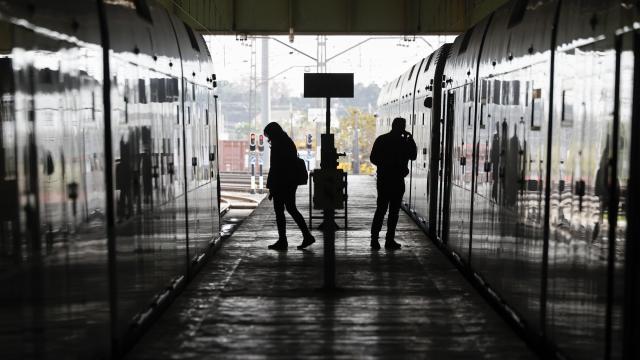 Dos personas transitan entre dos vagones de metro en los talleres de Metrovalencia, en una imagen de archivo. Efe / Biel Aliño