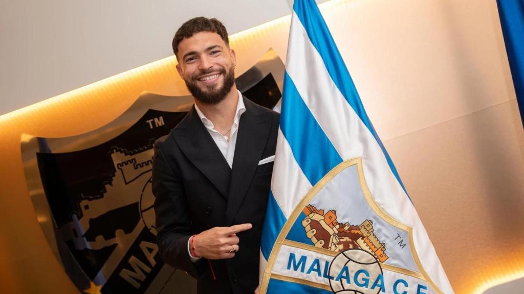 Dani Sánchez posa junto a la bandera del Málaga C. F.