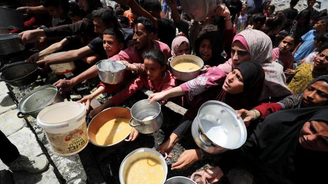 Palestinos esperan recibir un plato de comida preparada por una cocina benéfica en Jabalia, en el norte de la Franja de Gaza.