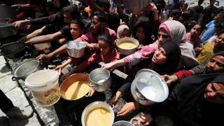 Palestinos esperan recibir un plato de comida preparada por una cocina benéfica en Jabalia, en el norte de la Franja de Gaza.
