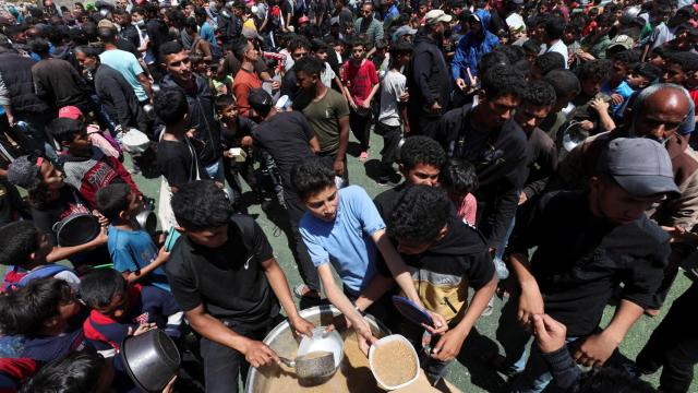 Miles de palestinos esperan recibir comida en el campo de refugiados Nuseirat.