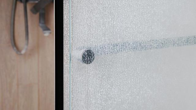 Cal acumulada en vidrio de ducha.