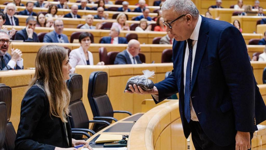 El senador del PP Francisco Bernabé entrega a la vicepresidenta tercera, Sara Aagesen, un saco lleno de estéril minero.