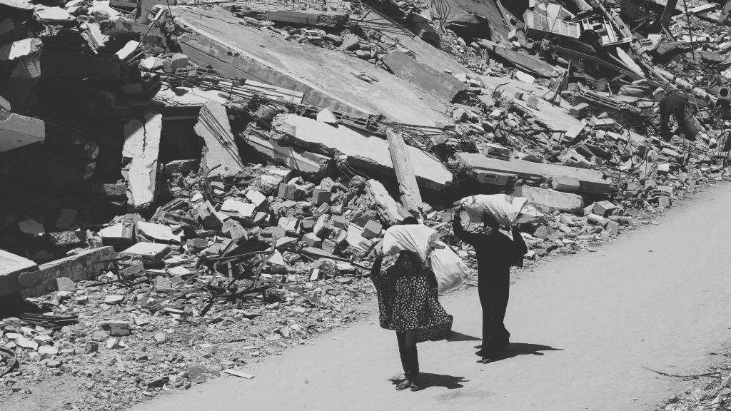 Dos mujeres palestinas portan bolsas en Gaza City.