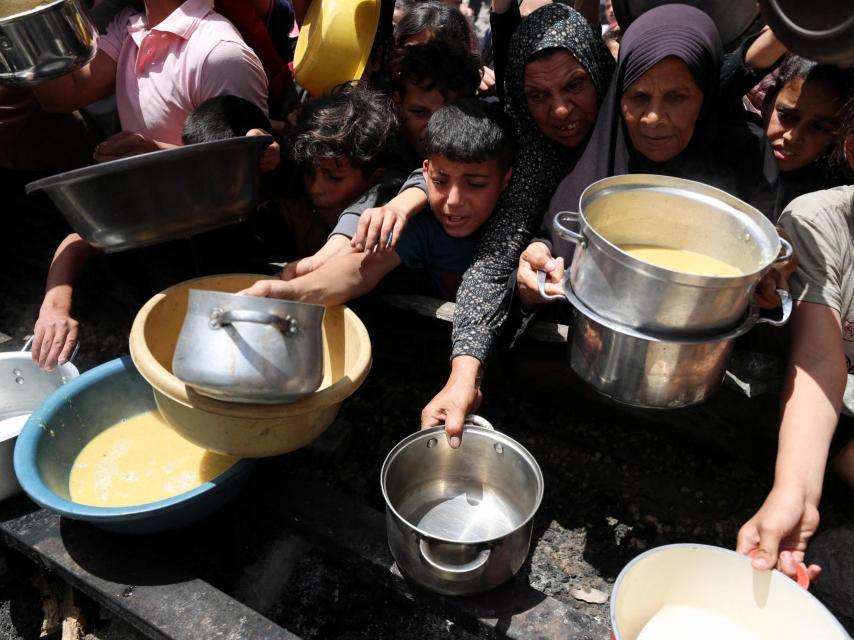 Palestinos esperan para recibir comida preparada por una cocina benéfica, en Jabalia, en el norte de la Franja de Gaza, el 19 de mayo de 2025.
