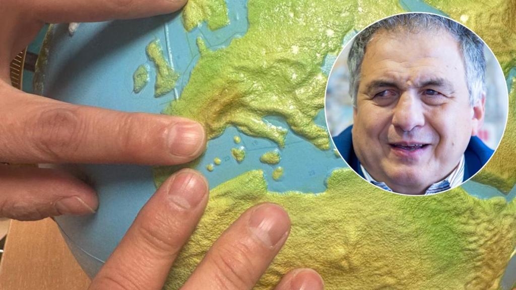 Carlos Javier Hernández y sus manos explorando los relieves en un globo terráqueo.