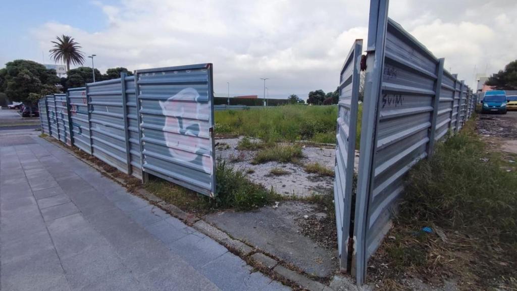 Parte abierta de una finca vallada de A Maestranza, con vehículos que aparcan a su lado.