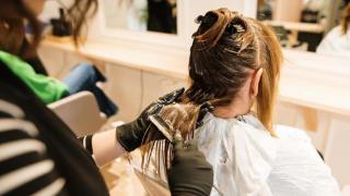 Mujer tiñéndose el cabello en la peluquería.