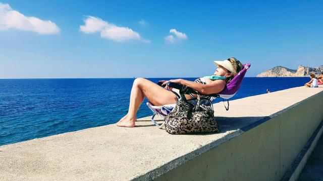 Una turista senior toma el sol en Benidorm.