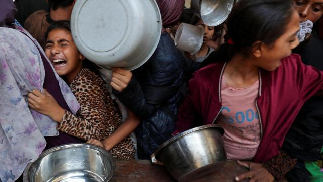 Niños palestinos esperan a recibir comida en una cocina benéfica en la ciudad de Gaza.