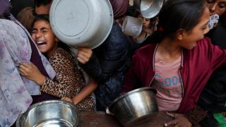 Niños palestinos esperan a recibir comida en una cocina benéfica en la ciudad de Gaza.
