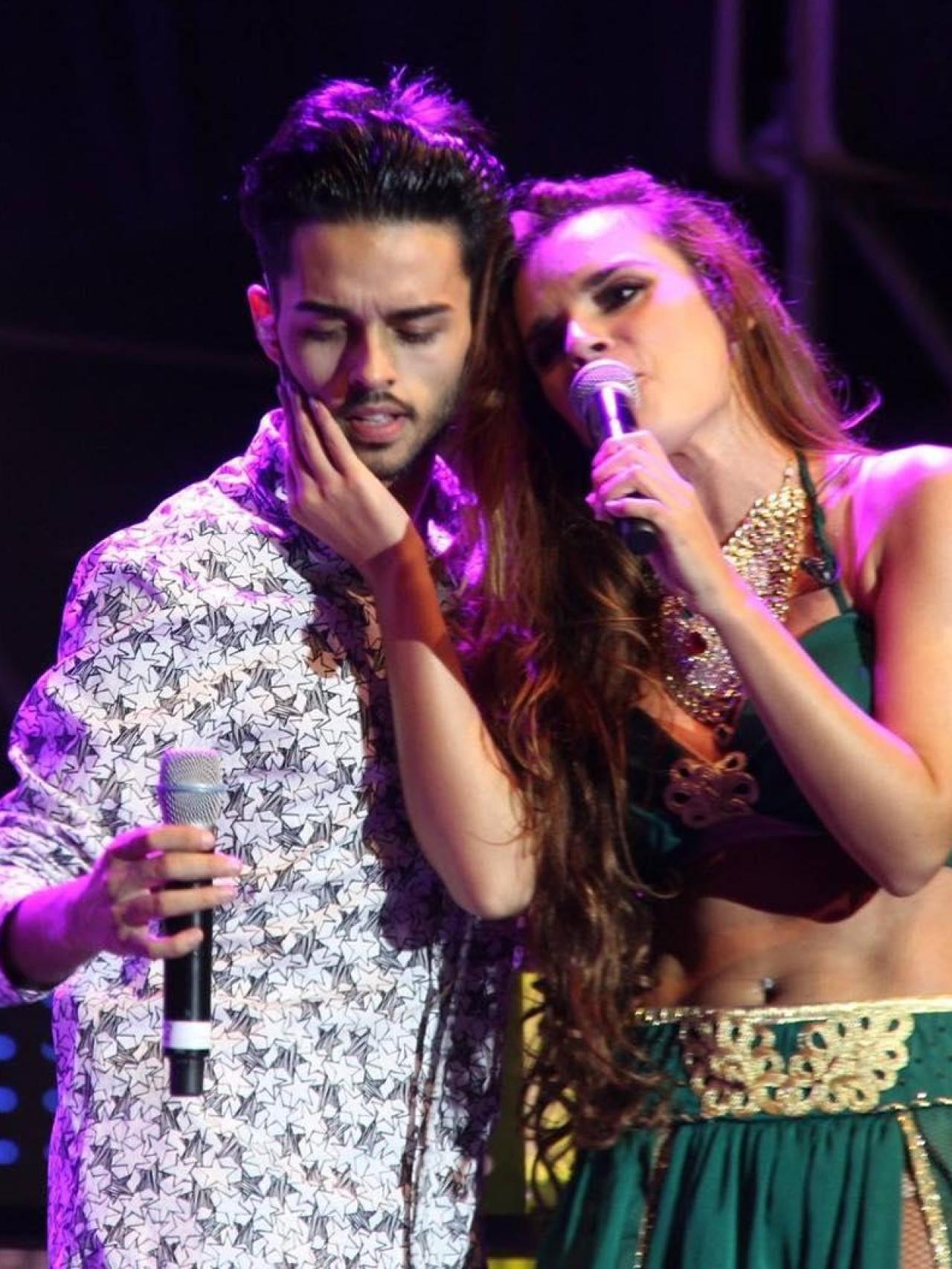 Melody y su hermano, Eleazar, cantando juntos en el escenario.