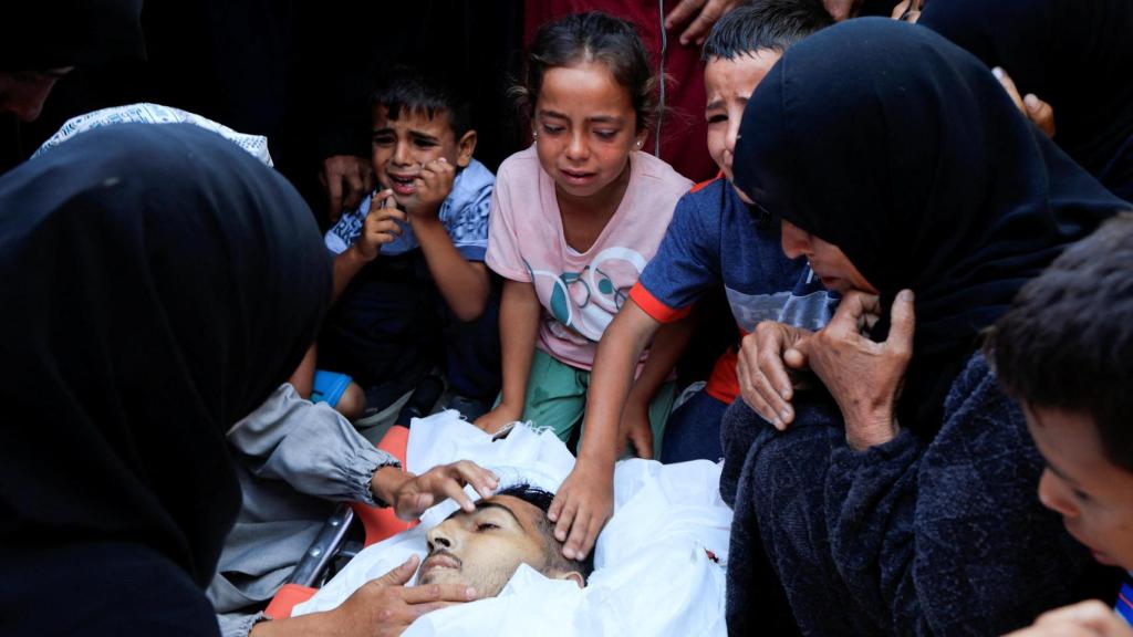 Unos niños lloran a un familiar muerto a causa de los bombardeos de Israel.