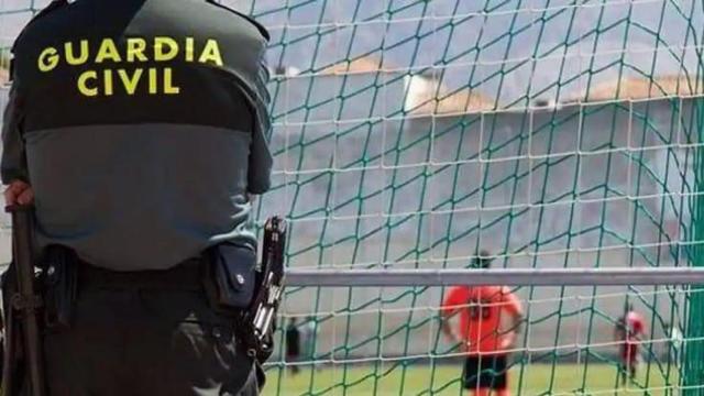 Un agente de la Guardia Civil de espaldas contemplando el campo de fútbol.
