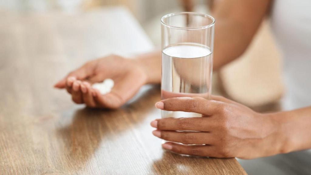 Mujer tomando suplemento de magnesio.