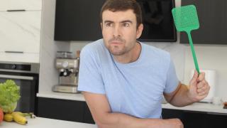 Una persona concentrada intentando dar caza a una mosca