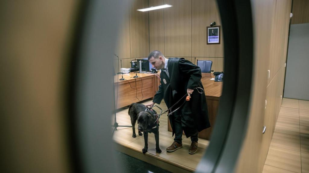 Héctor sujeta a su perro guía. Biel Aliño