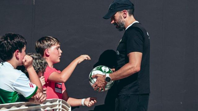 El entrenador Eder Sarabia firma unos autógrafos a unos niños.