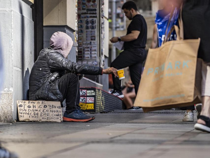 Otro mendigo en el centro de Madrid pide comida y dinero. Por favor. Tengo 3 hijos. Ayúdame, avisa en un cartel.