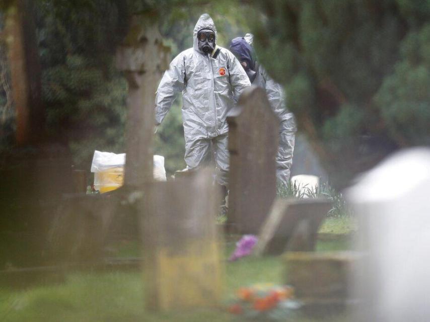 Servicios de emergencia se ayudan a quitarse los trajes de protección en la tumba de Liudmila Skripal, esposa del exespía ruso Serguéi Skripal, en Salisbury, en 2018.
