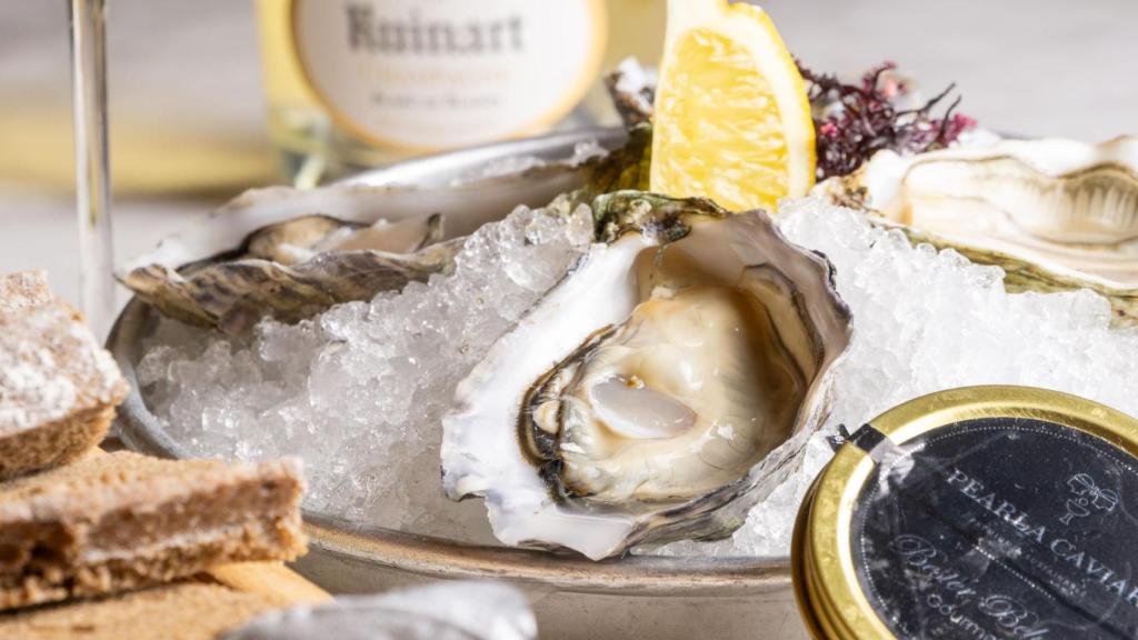 El servicio completo de ostras, con champán, pan, mantequilla y caviar.