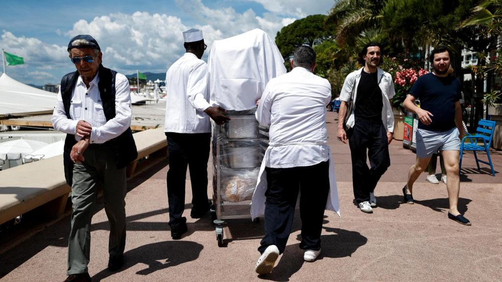 Los cocineros sacan la comida del Carlton Hotel Beach Club en la Croisette después de un importante corte de electricidad, durante el 78º Festival de Cine de Cannes.