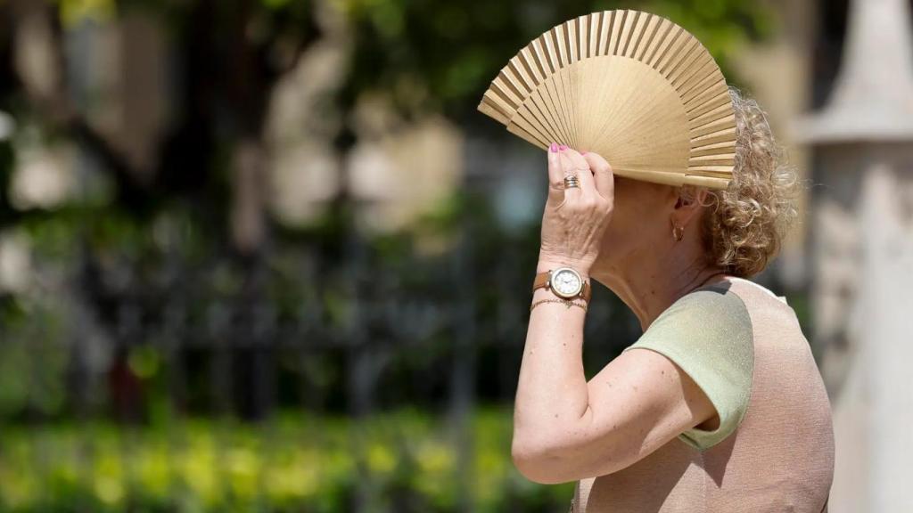 Una mujer se protege del sol y del calor.