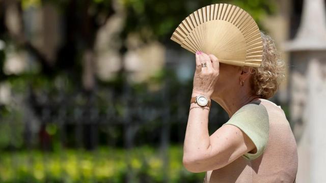 Una mujer se protege del sol y del calor.