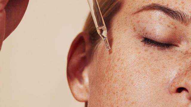 Una mujer se aplica un sérum facial
