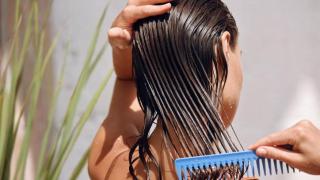 Mujer cepillándose el pelo mojado.