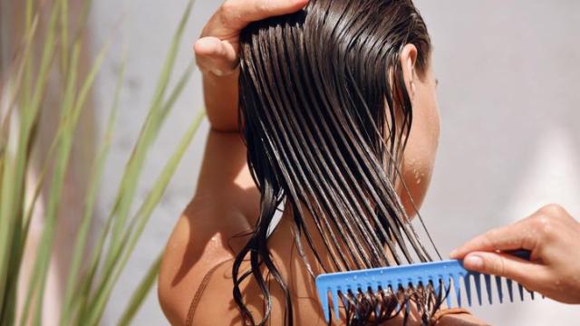 Mujer cepillándose el pelo mojado.